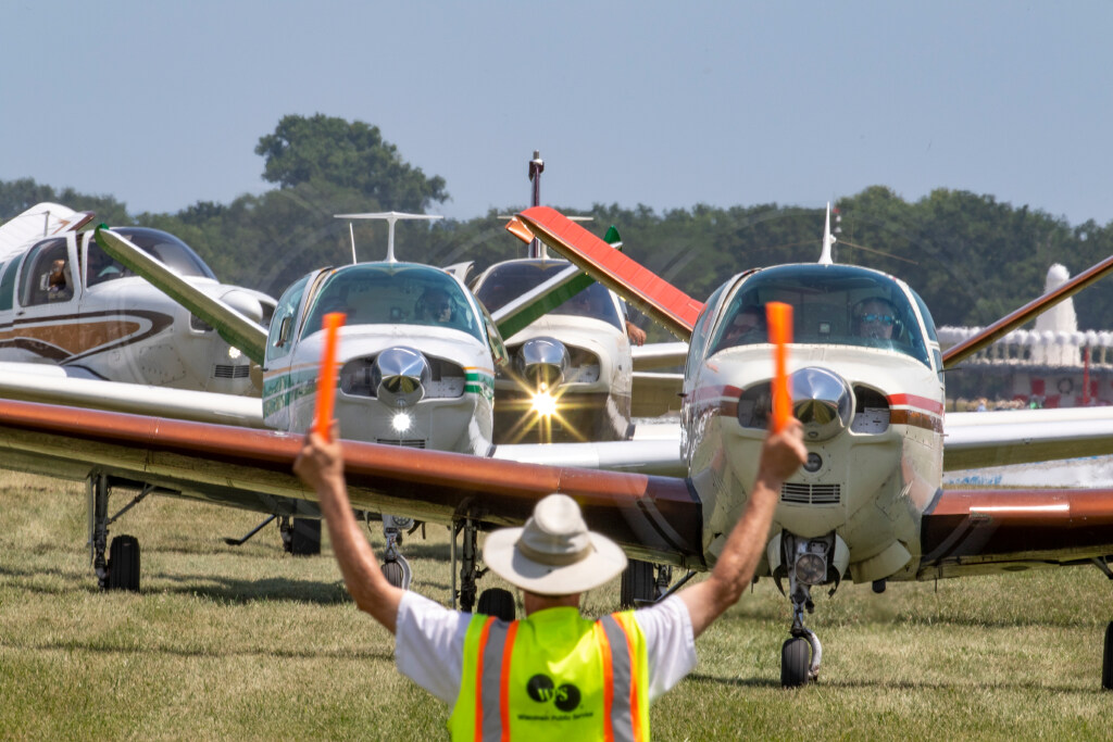 Volunteer marshalling arriving aircraft during a mass arrival