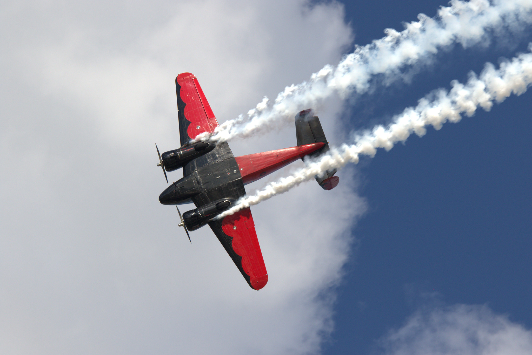 red and black plane flying with smoke | airventure 2023 performers confirmed