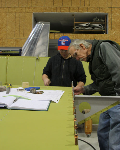 Bill Phipps inspects the work of one of the TeenFlight members.